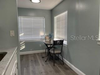 A small dining nook features light blue walls, wood-look flooring, and two windows with blinds — 416 MONROE AVENUE UNIT F201, CAPE CANAVERAL, FL