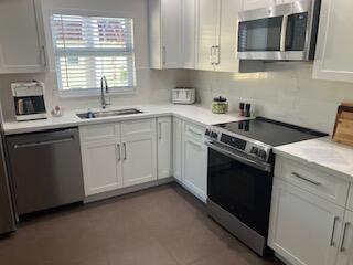 A kitchen with white cabinets, stainless steel appliances, and a window above the sink — 717 S Us Highway 1 # 608, Jupiter FL 33477, JUPITER, FL