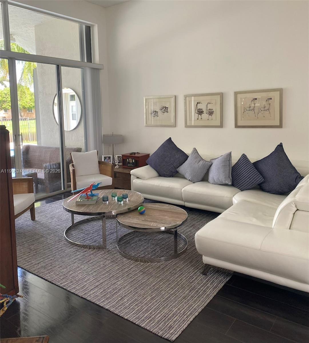 A living room features a white sectional sofa, nesting coffee tables, and a large rug — 3066 Lakewood Cir, Weston FL 33332, WESTON, FL