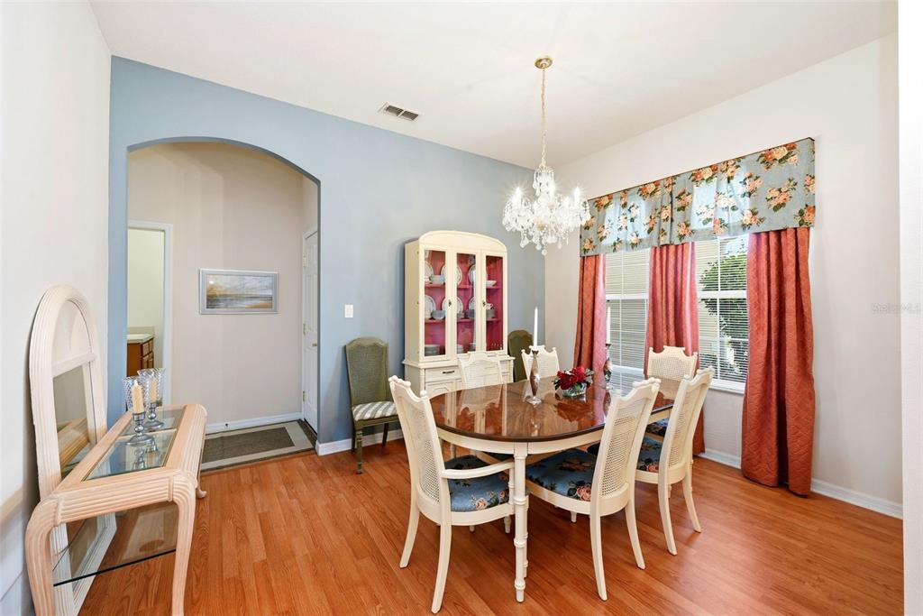 A dining room with a wooden table, chairs, a hutch, and a crystal chandelier — 3810 ST EMMA COURT, LEESBURG, FL