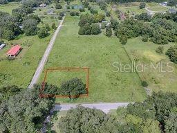 An aerial view shows a rectangular plot of land outlined in red within a field — CR 763, BUSHNELL, FL
