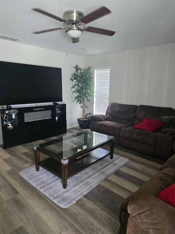 A kitchen features dark wood cabinets, white countertops, stainless steel appliances, and a tiled backsplash — 13303 PINYON DRIVE, CLERMONT, FL