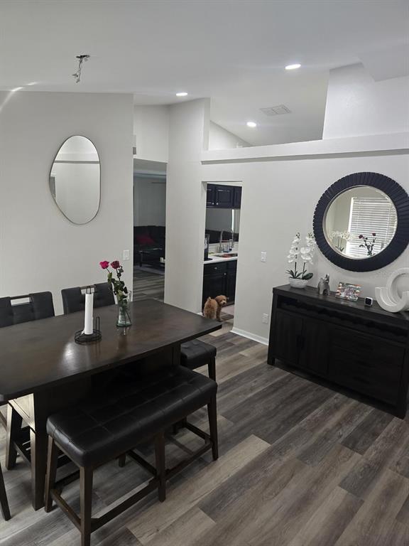 A kitchen features black cabinets, white countertops, a tiled backsplash, and wood-look flooring — 13303 PINYON DRIVE, CLERMONT, FL