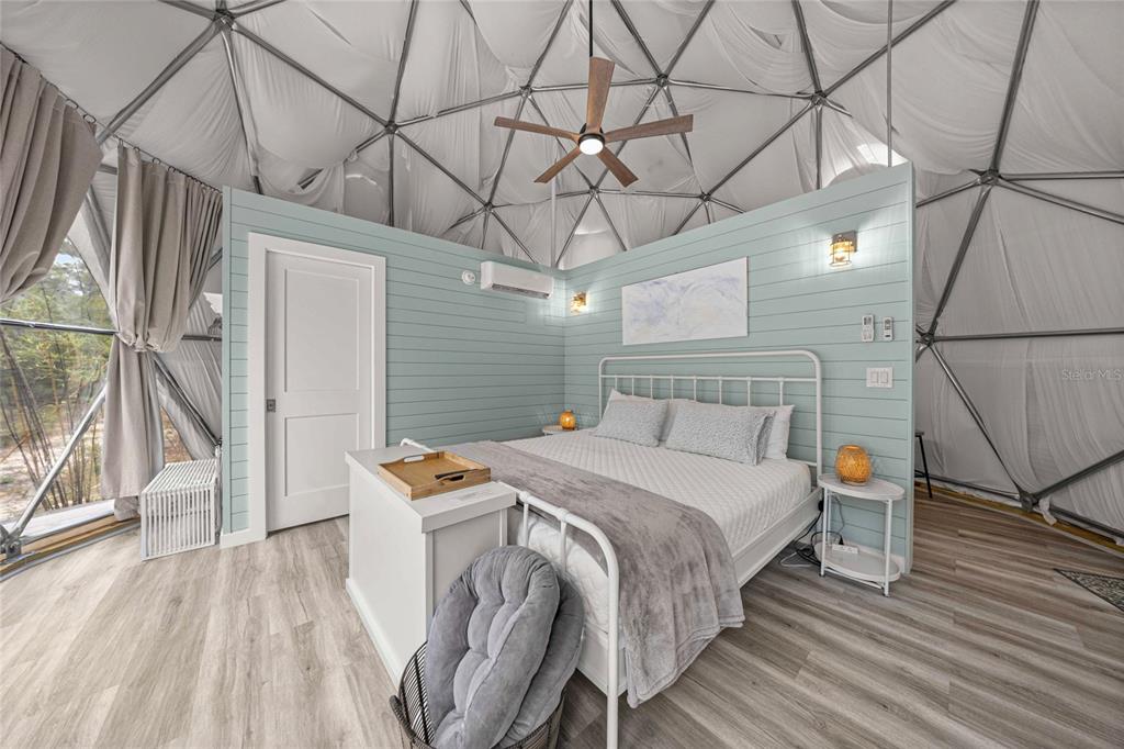 A bedroom inside a geodesic dome features light blue shiplap walls and a white bed — 414 S SCHOOL AVENUE, LECANTO, FL