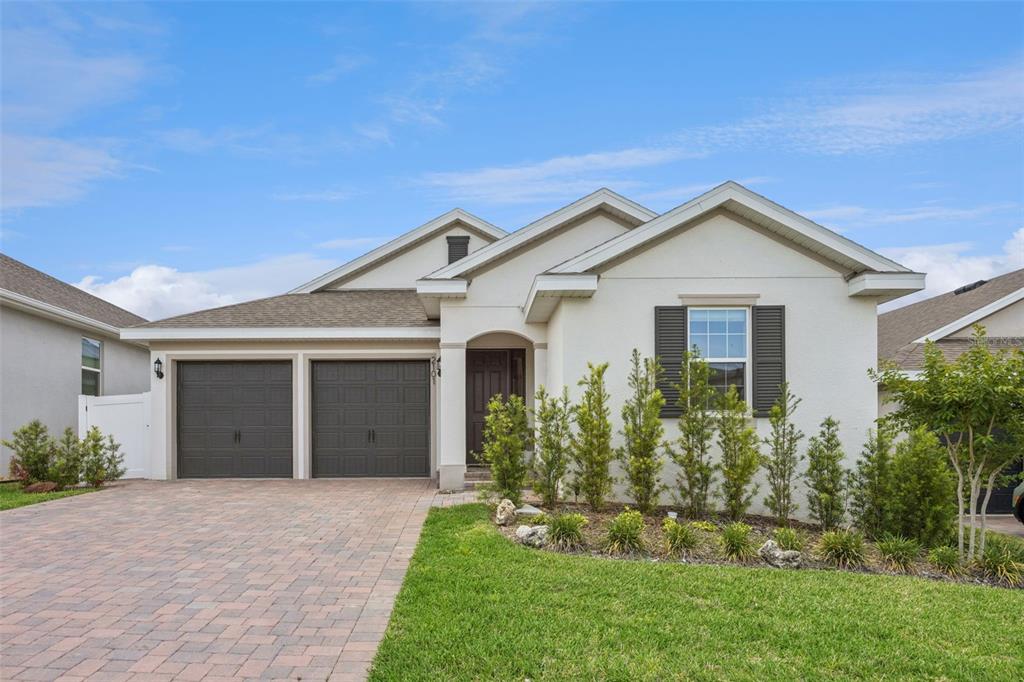 A single-story house with a two-car garage, stucco exterior, and a paved driveway — 2101 AXEL STREET, CLERMONT, FL