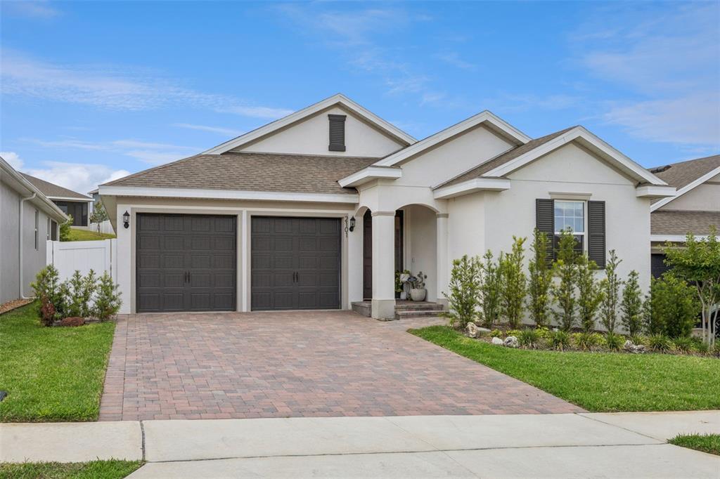 A single-story house with a two-car garage, a paved driveway, and a covered entryway — 2101 AXEL STREET, CLERMONT, FL