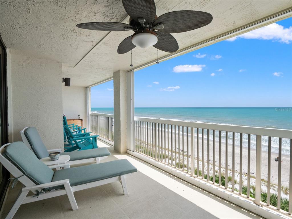 A balcony with lounge chairs and a ceiling fan overlooks the ocean and beach — 407 HIGHWAY A1A UNIT 443, SATELLITE BEACH, FL