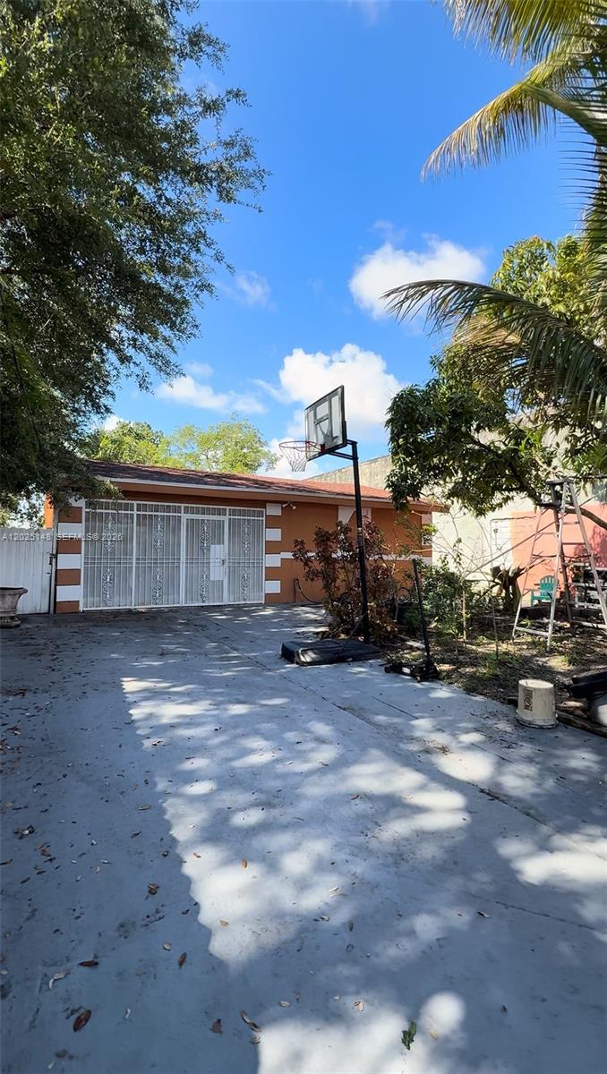 A paved driveway leads to a single-story house with a basketball hoop in the yard — 110 NW 52nd St, Miami FL 33127, MIAMI, FL