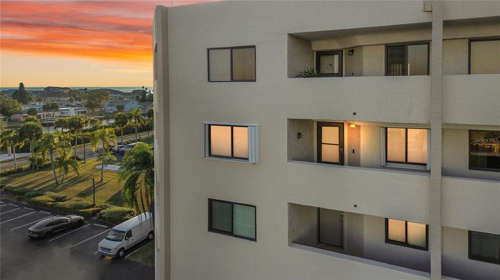 An exterior view of a multi-story apartment building with balconies and a parking lot — 6035 SEA RANCH DRIVE UNIT 415, HUDSON, FL