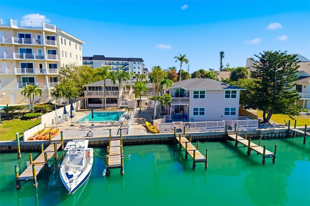 An aerial view of two waterfront houses with private docks, a swimming pool, and a boat — 9022 MIDNIGHT PASS ROAD, SARASOTA, FL