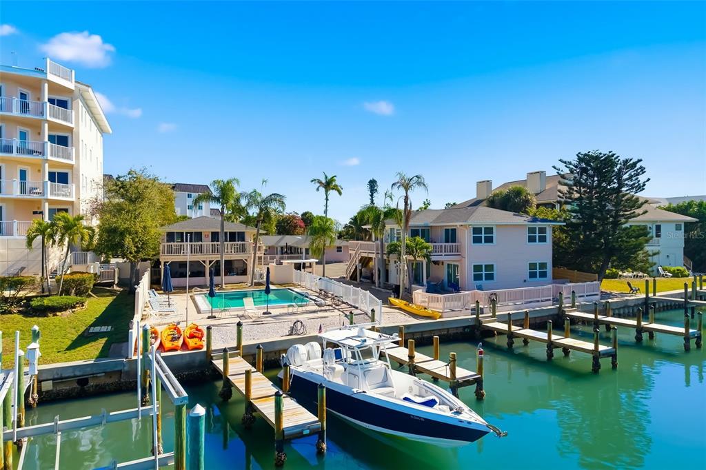 An aerial view shows a waterfront property with a swimming pool, boat docks, and buildings — 9022 MIDNIGHT PASS ROAD, SARASOTA, FL