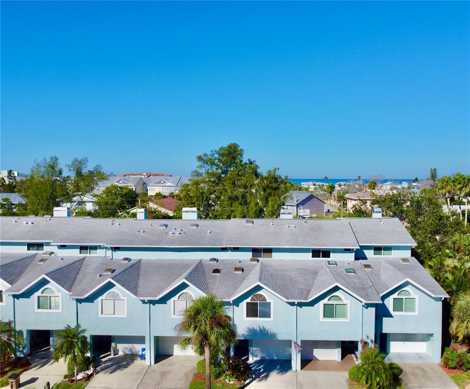 An aerial view of a row of light blue townhouses with gray shingled roofs — 603 GARLAND CIRCLE, INDIAN ROCKS BEACH, FL