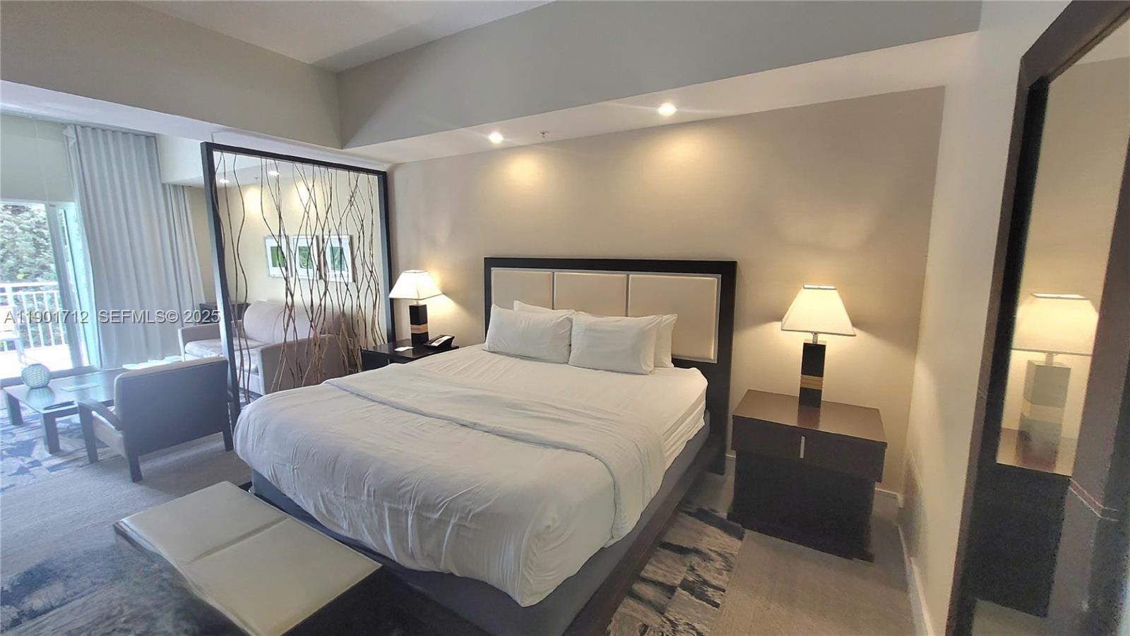 A bedroom features a king bed, two nightstands with lamps, and a decorative room divider — 5300 NW 87th Ave # 306, Doral FL 33178, DORAL, FL