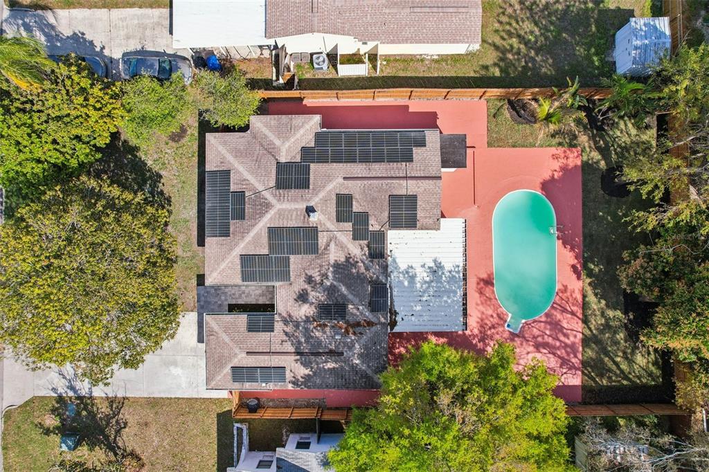 An aerial view shows a house with solar panels on the roof and a swimming pool — 5010 8th AVE N, ST PETERSBURG, FL