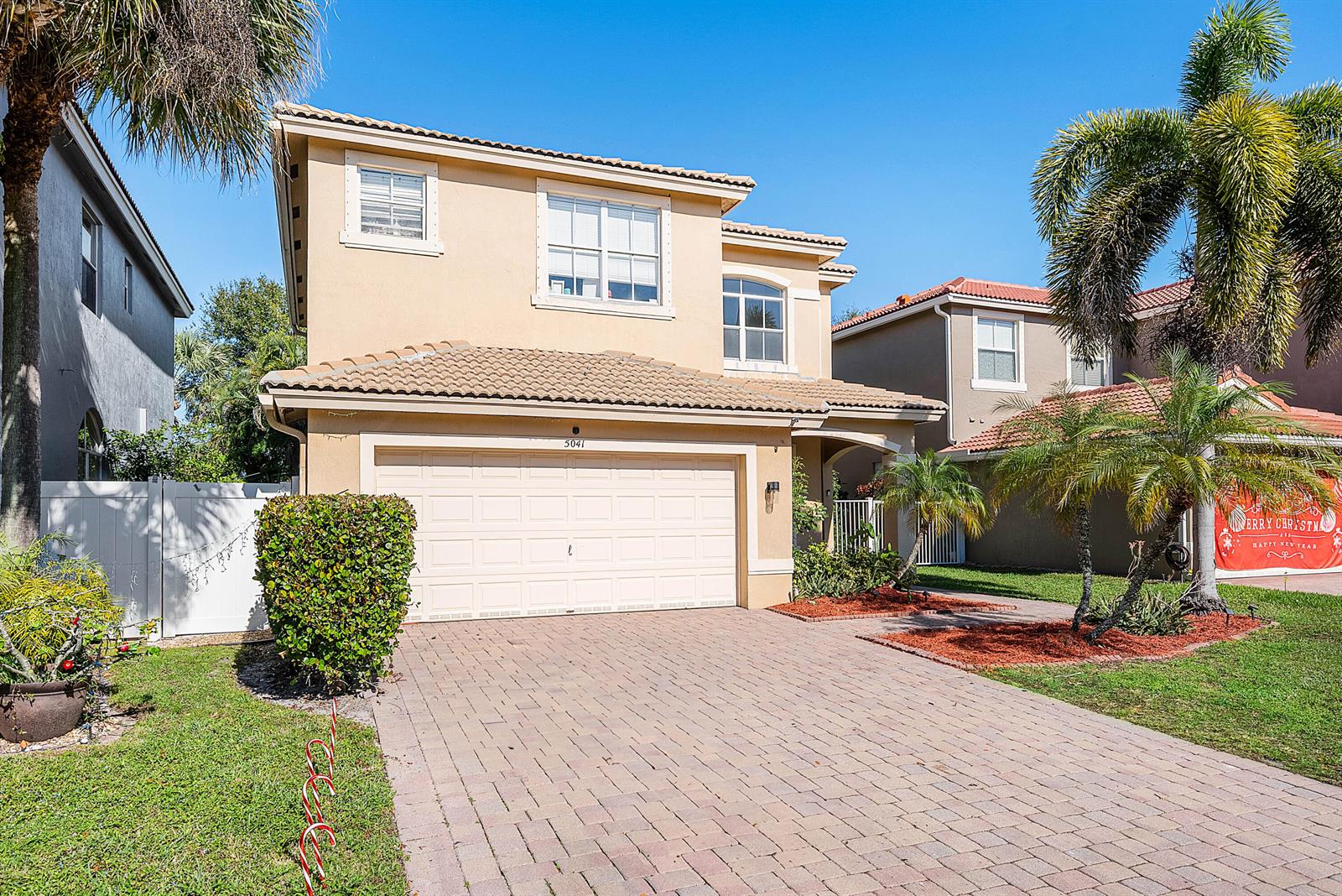 A two-story tan house with a tiled roof and a paved driveway — 5041 Massy Drive, Lake Worth FL 33463, LAKE WORTH, FL