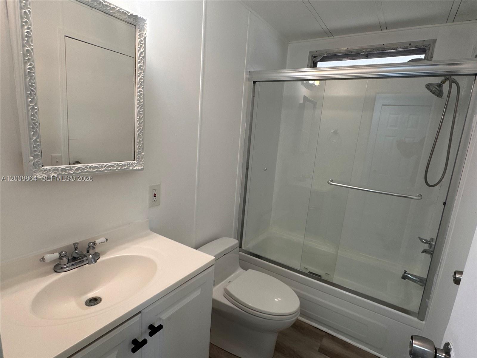 A bathroom features a white vanity, a toilet, and a shower-tub combination with sliding doors — 2957 SW 54th St # 0, Dania Beach FL 33312, DANIA BEACH, FL