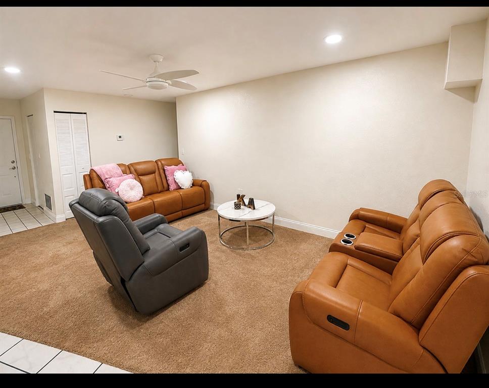 A living room features brown leather sofas, a grey recliner, and a round coffee table — 1618 CRYSTALVIEW TRAIL, LAKELAND, FL