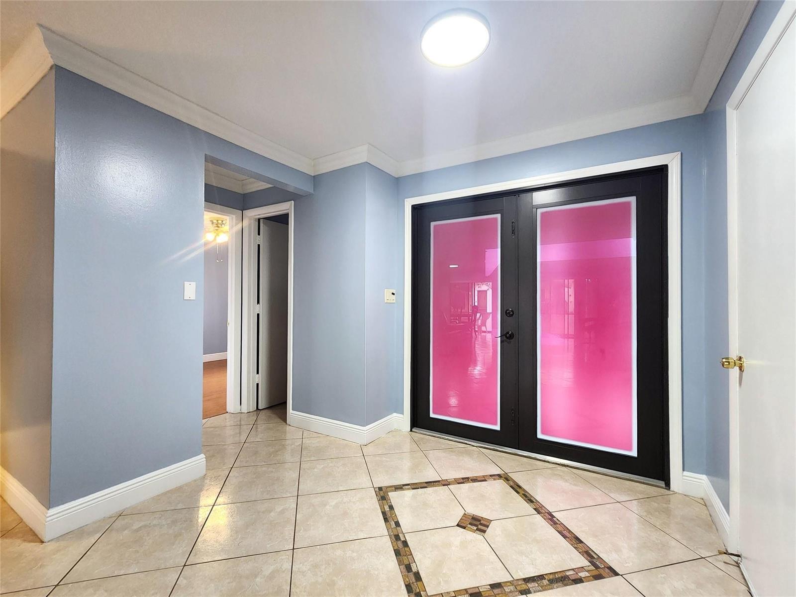 A foyer with light blue walls, tile flooring, and black double doors with pink glass — 1572 SW 23rd Terrace, Deerfield Beach FL 33442, DEERFIELD BEACH, FL