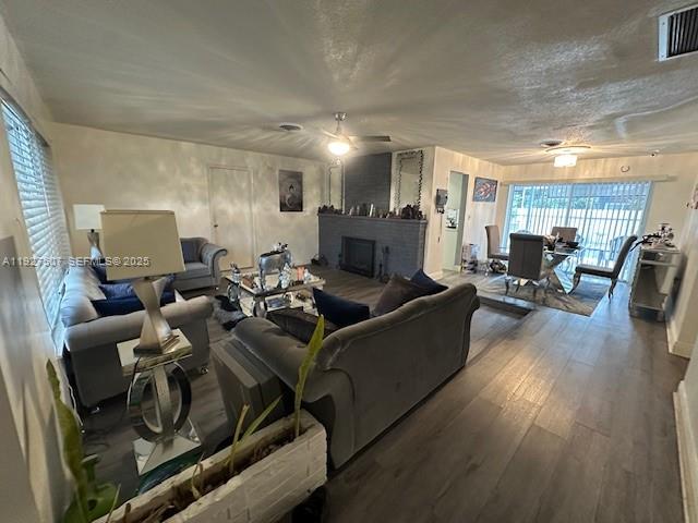 A living room features a gray sofa, a fireplace, and wood-look flooring — 6757 Arbor Dr, Miramar FL 33023, MIRAMAR, FL