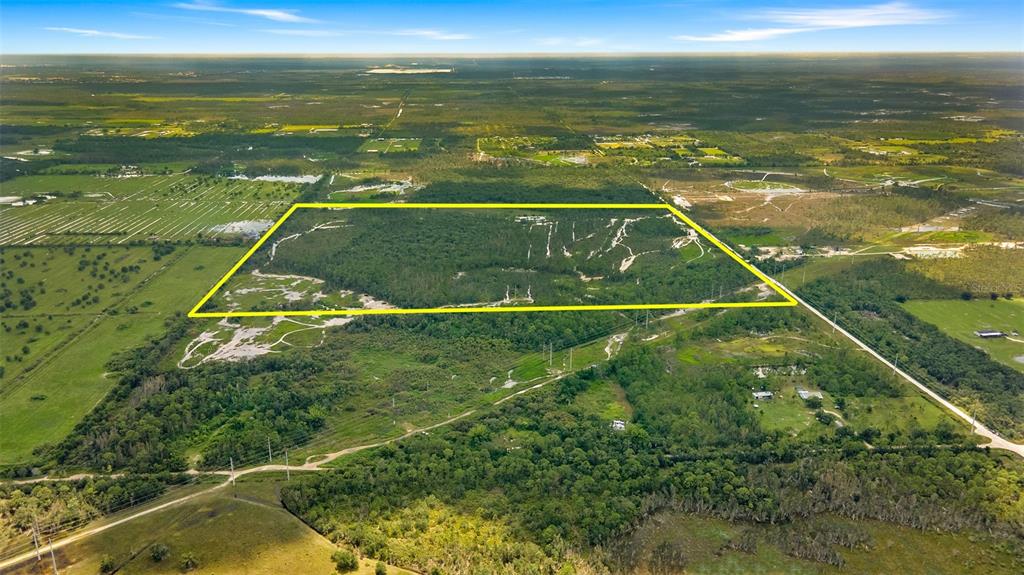 An aerial view shows a large, rectangular plot of undeveloped land outlined in yellow — 37381 COOK BROWN ROAD, FORT MYERS, FL