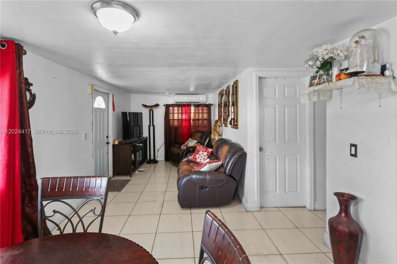 A living room features tile flooring, a brown leather sofa, and a white door — 827 SW 128 AVE, Miami FL 33184, MIAMI, FL