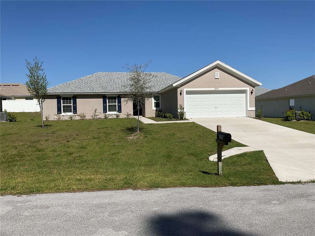 A single-story house with a beige exterior, a two-car garage, and a gray shingled roof — 8190 N WAKEFIELD DRIVE, CITRUS SPRINGS, FL