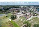 An aerial view shows a low-rise commercial building with a parking lot and surrounding land — 1001 LAKEVIEW DRIVE, SEBRING, FL