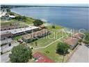 An aerial view shows apartment buildings situated on a grassy lot next to a lake — 1001 LAKEVIEW DRIVE, SEBRING, FL