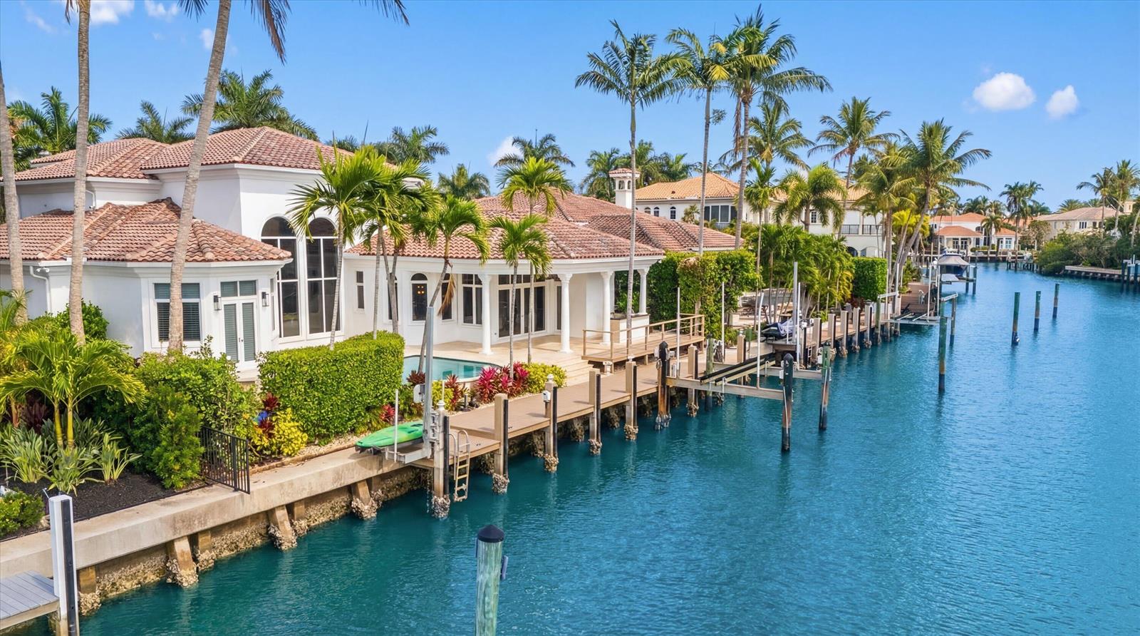 An aerial view of a waterfront house with a pool, dock, and palm trees — 788 Harbour Isles Place, North Palm Beach FL 33410, NORTH PALM BEACH, FL