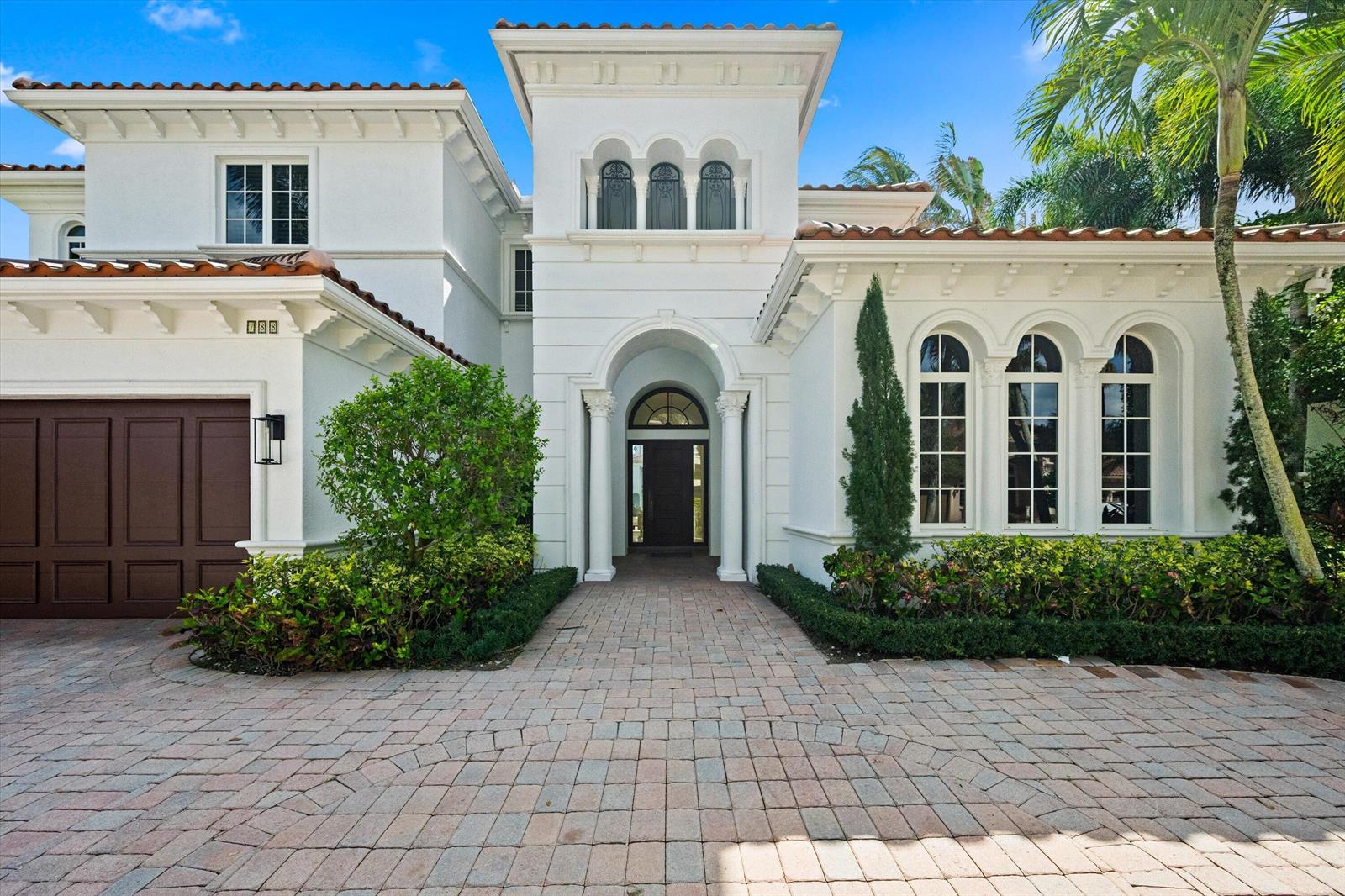 A two-story white stucco house features a tiled roof, arched windows, and a paved driveway — 788 Harbour Isles Place, North Palm Beach FL 33410, NORTH PALM BEACH, FL