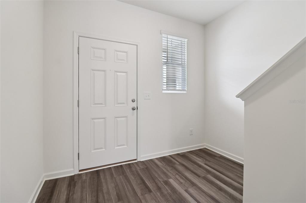 An entryway with white walls, a white door, a window, and wood-look flooring — 3676 SPIRE DRIVE, DAVENPORT, FL