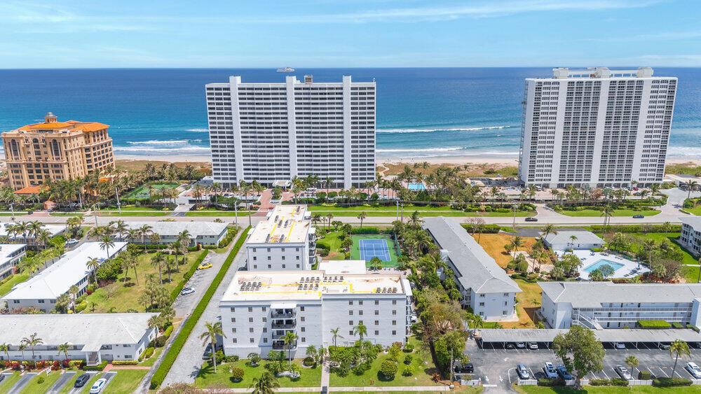 An aerial view shows several apartment buildings, a tennis court, and a beach with ocean — 2679 S Ocean Boulevard # 31, Boca Raton FL 33432, BOCA RATON, FL