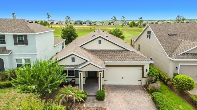 An elevated exterior view of a suburban house with a paved driveway and garage — 2427 ZABALLINA PLACE, DAVENPORT, FL