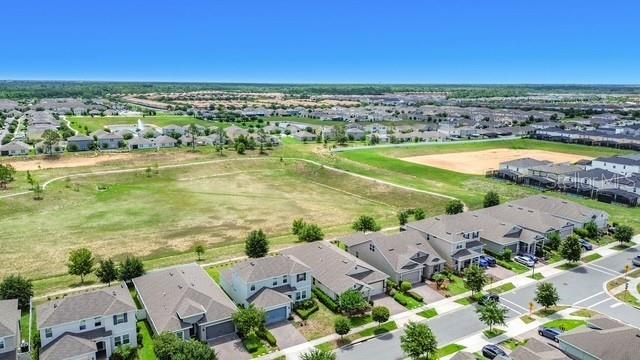 This is an aerial view of a suburban neighborhood with houses and open green space — 2427 ZABALLINA PLACE, DAVENPORT, FL