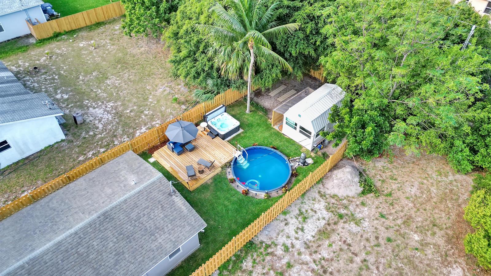 An aerial view of a backyard featuring a wooden deck, hot tub, and circular pool — 240 NW 9th Avenue, Delray Beach FL 33444, DELRAY BEACH, FL