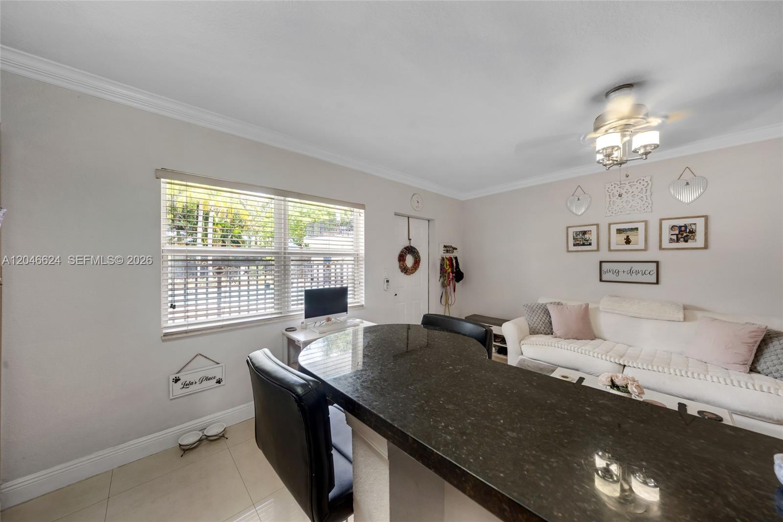 A living room features a dark granite kitchen island, a white sofa, and a window — FORT LAUDERDALE, FL