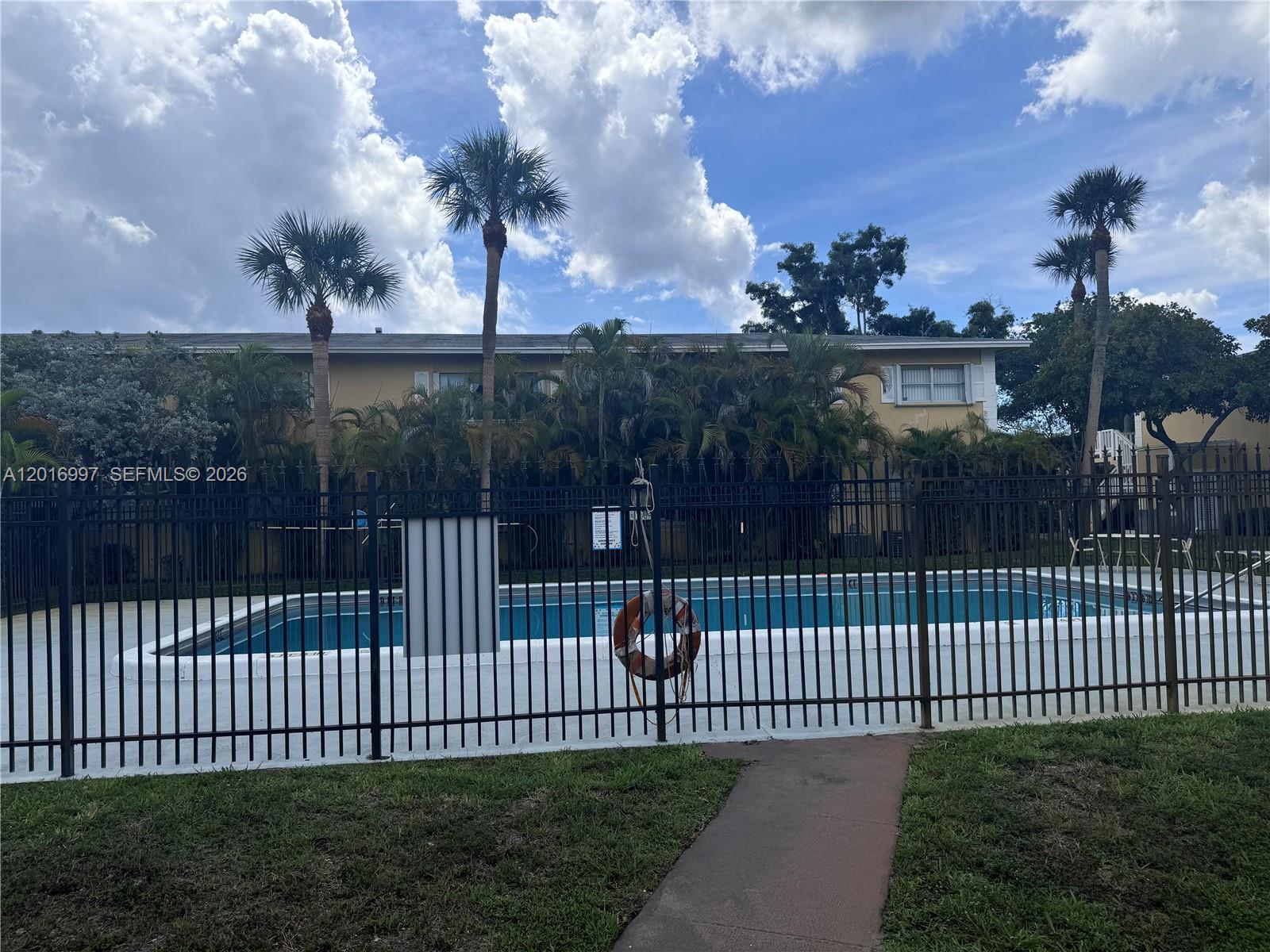 A swimming pool is enclosed by a black metal fence in front of a building — 410 SE 2nd Ave # 21, Deerfield Beach FL 33441, DEERFIELD BEACH, FL