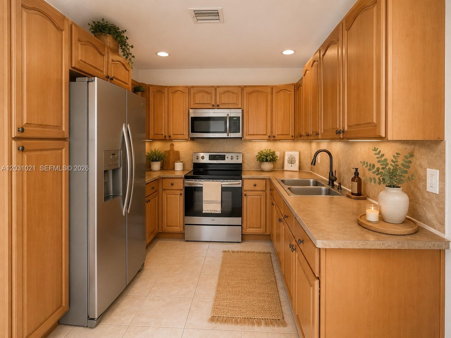 A kitchen features light wood cabinets, stainless steel appliances, and tan countertops — 15410 NW 29th Ct # A, Miami FL 33054, MIAMI, FL