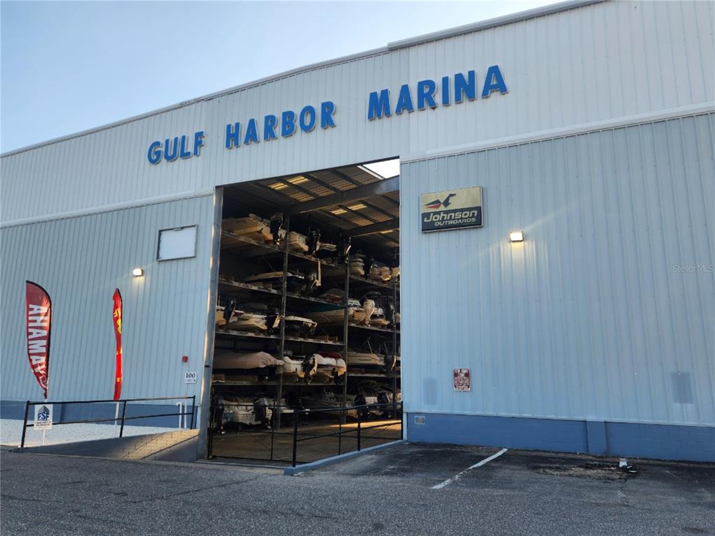 The exterior of a light blue commercial building features a central cupola and double glass doors — 100 CIRCUIT ROAD UNIT S127, NOKOMIS, FL