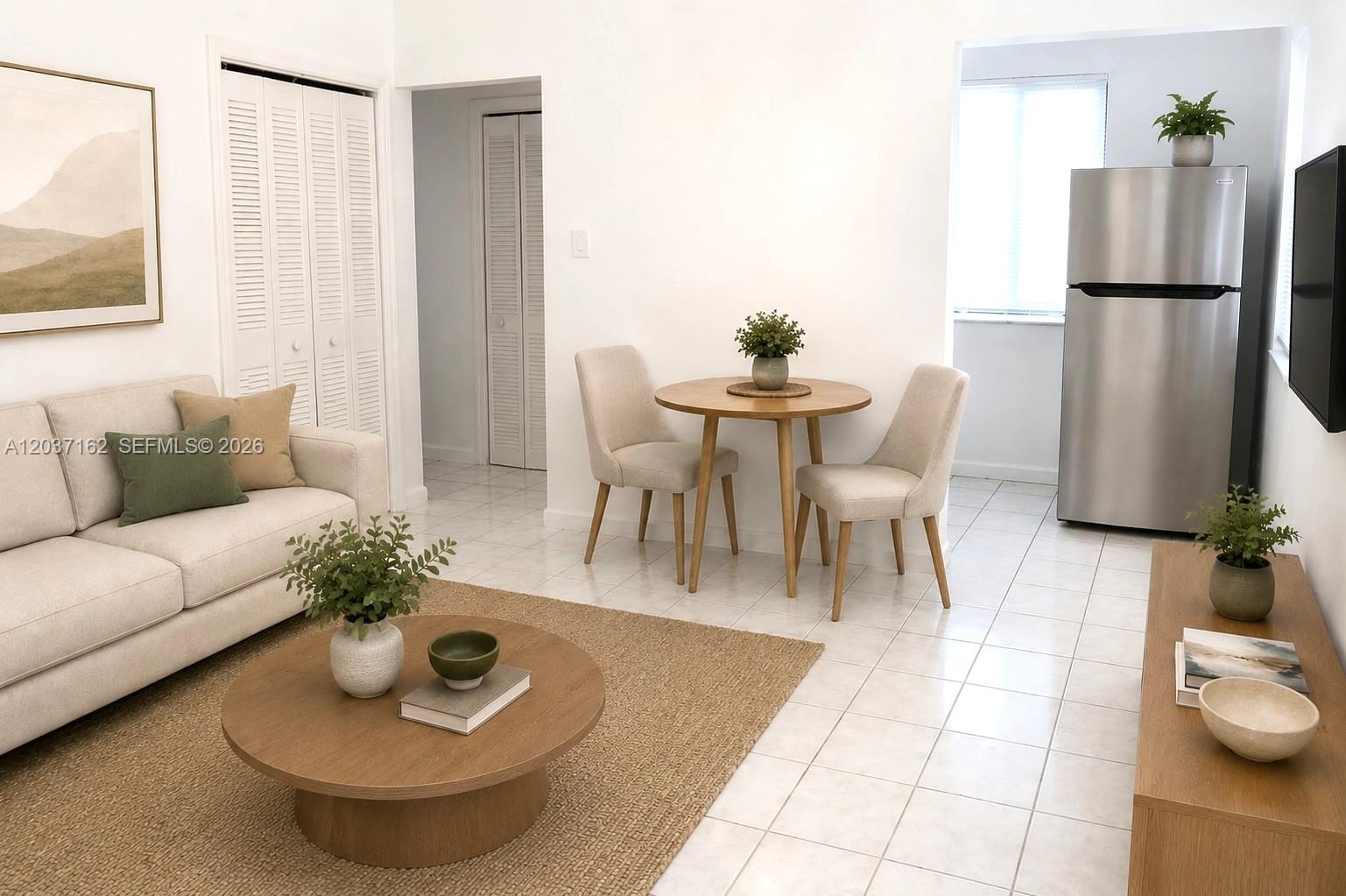 This living and dining area features a beige sofa, round wooden table, and tile flooring — 1035 SW 4th St # 4, Miami FL 33130, MIAMI, FL