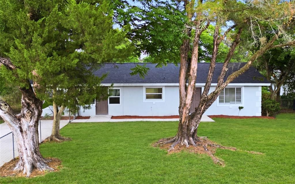 A single-story house with a light-colored exterior, dark roof, and two front doors — 1715 SUNSET DRIVE, LONGWOOD, FL