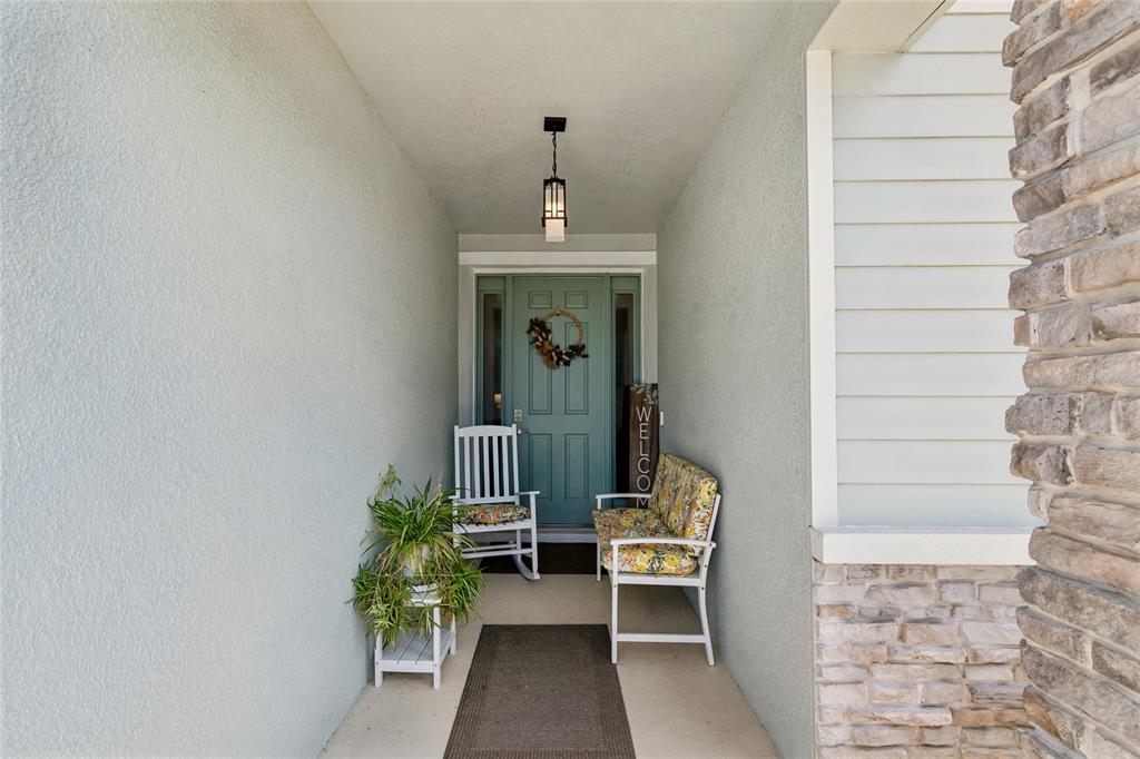 A single-story house with a paved driveway, light green siding, and a stone-accented entryway — 18123 GULF RANCH PLACE, LAKEWOOD RANCH, FL