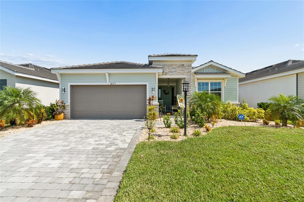 An aerial view shows a single-story suburban house with a paved driveway and tile roof — 18123 GULF RANCH PLACE, LAKEWOOD RANCH, FL