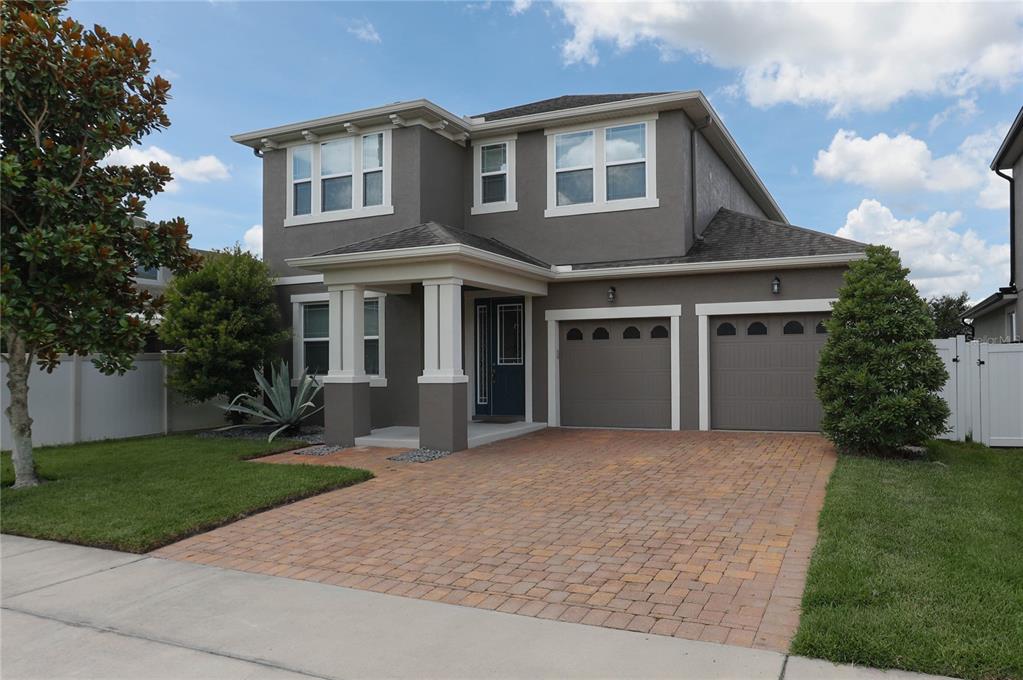 A two-story house with a gray exterior, a brick paver driveway, and a two-car garage — 2963 SERA BELLA WAY, KISSIMMEE, FL