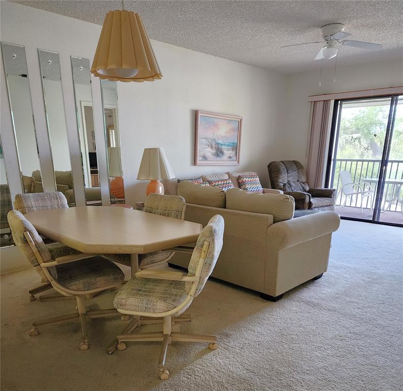 A dining area with a table and chairs sits adjacent to a living room — 4056 OAKVIEW DRIVE UNIT E10, PORT CHARLOTTE, FL