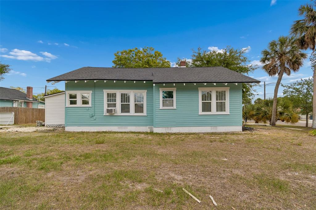 The exterior of a light blue, single-story house with a dark shingled roof and palm trees — 4105 18TH AVENUE S, ST PETERSBURG, FL