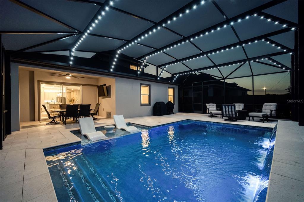 A screened-in patio features a swimming pool with lounge chairs and a covered dining area — 13175 MCMILLAN, ORLANDO, FL