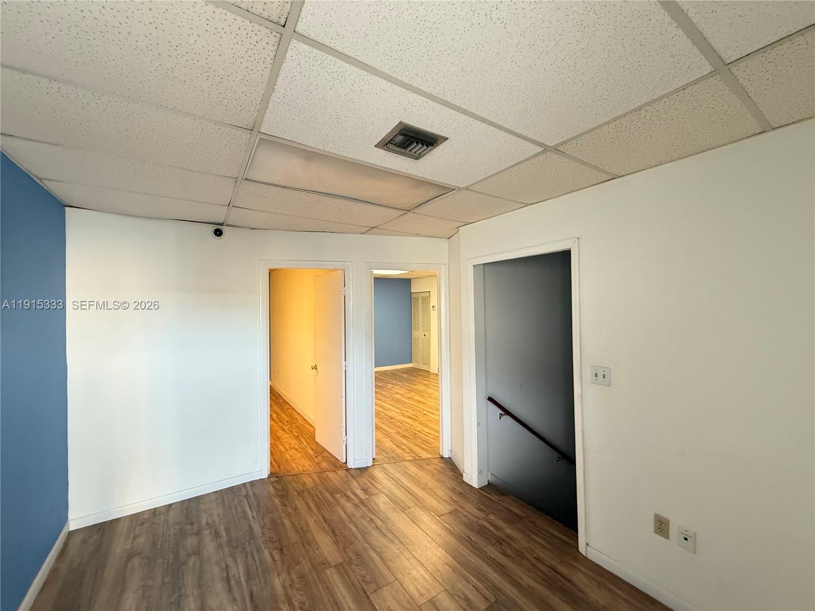 An interior view shows a room with wood-look flooring, white walls, and a drop ceiling — 8000 NW 31st St # 19, Doral FL 33122, DORAL, FL