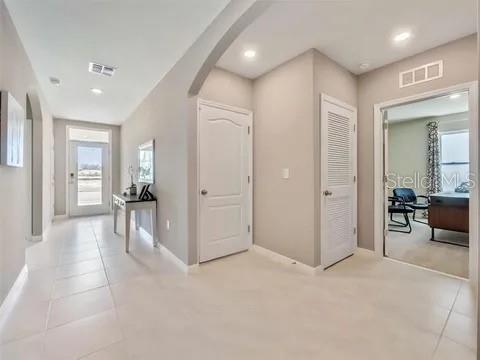 A bright entryway features light tile flooring, neutral walls, and a white door — 679 MADRID DRIVE, KISSIMMEE, FL