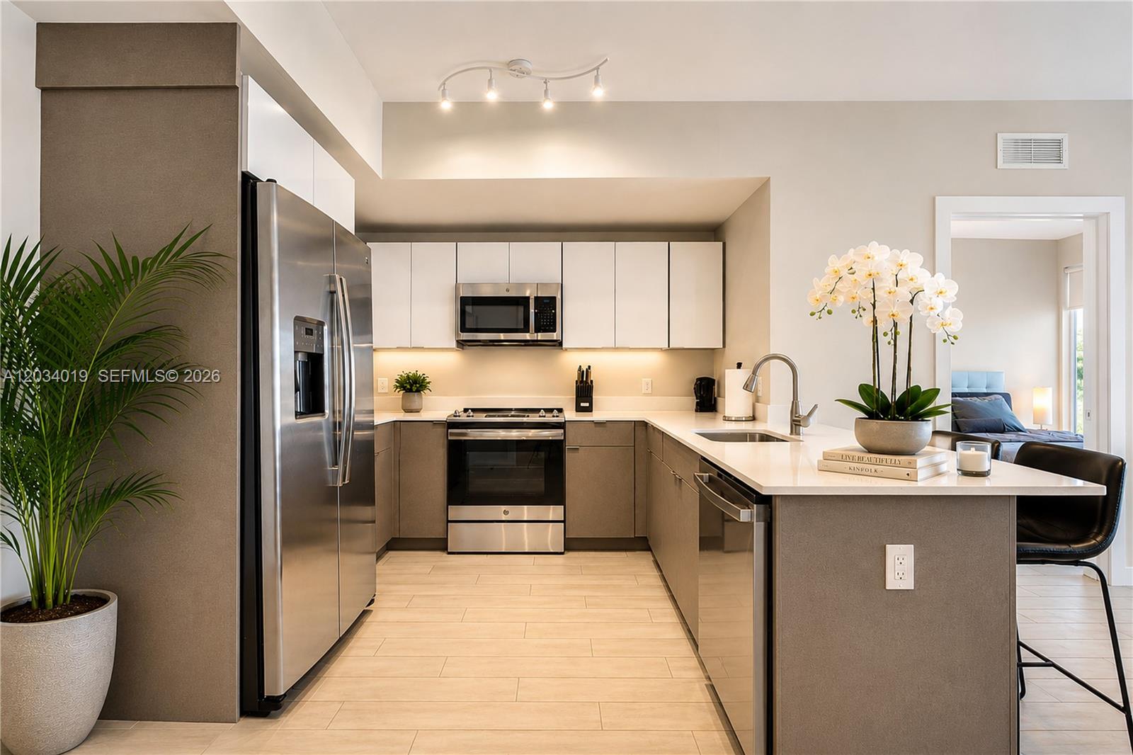A modern kitchen features stainless steel appliances, white upper cabinets, gray lower cabinets, and a peninsula — 321 NE 26th St # 806, Miami FL 33137, MIAMI, FL